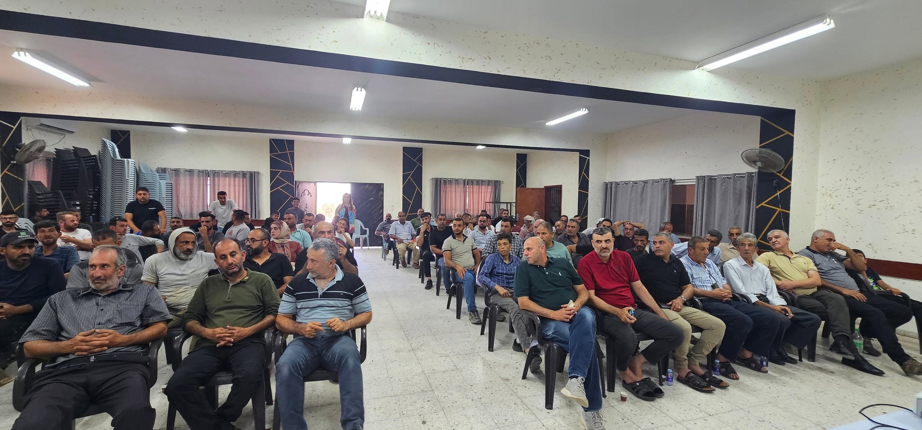 حضور لقاء مجتمعي يجلسون في صفوف داخل قاعة