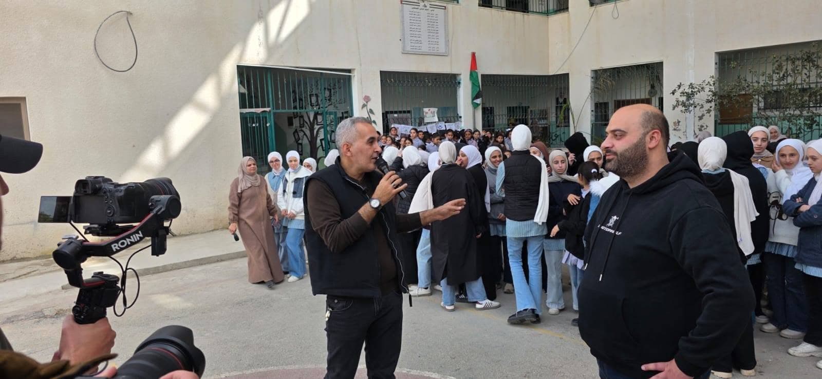 لقاء وحديث أمام مجموعة من المشاركين في ساحة مدرسة