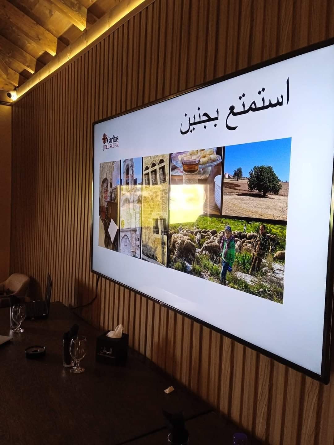شاشة تعرض صورًا للتعريف بالسياحة في جنين تحت عنوان استمتع بجنين